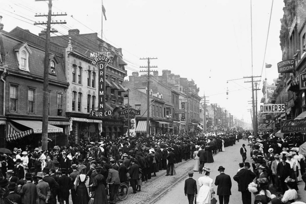 Yonge Street in the early 1900s is lined with people celebrating a Labour Day Parade. 