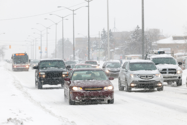 Cars are driving slowly and allowing ample space between cars during a storm in Toronto. 