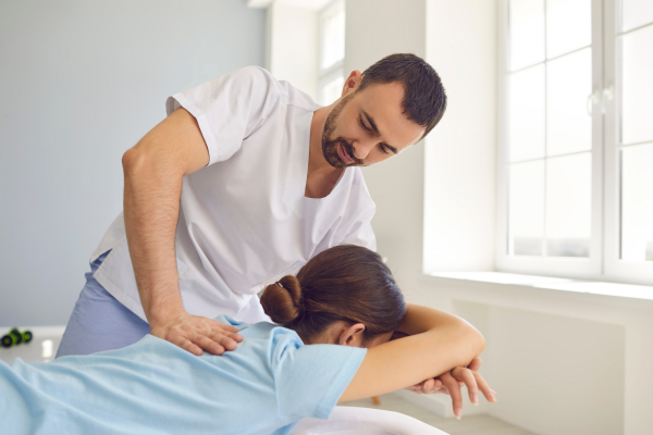 A chiropractor in Canada performing a chiropractic adjustment on a female patient.