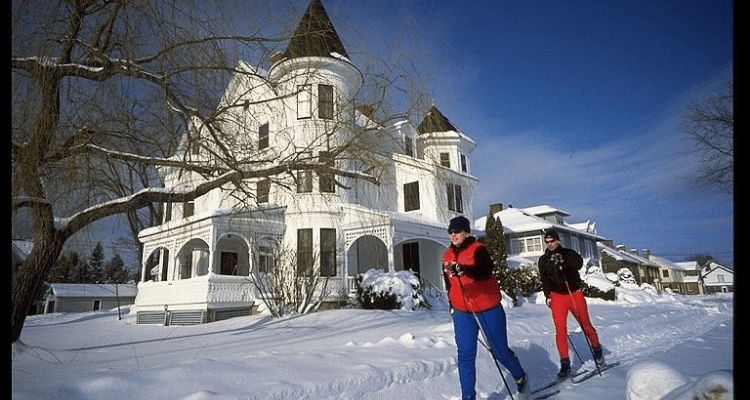 Cross country skiers in front of a Victorian home in Fredericton
