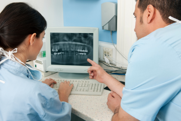 Male and female dentists reviewing dental x-rays