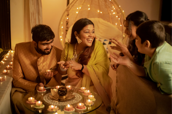 A family of four are gathered and lighting diyas to celebrate the five days of Diwali in 2023.