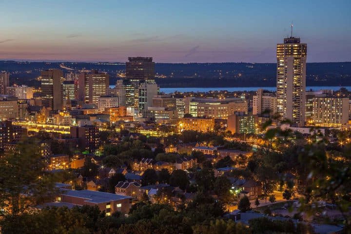 Hamilton, Ontario skyline at dusk with Lake Ontario in the background.  Learn more about living in Hamilton, Ontario