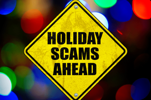 A yellow traffic sign with text that reads holidays scams ahead. The sign appears over red, green, and blue holiday season lights. 