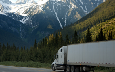 A transport truck is driving through the mountains in Canada. Transport truck drivers are in high demand due to a labour shortage.