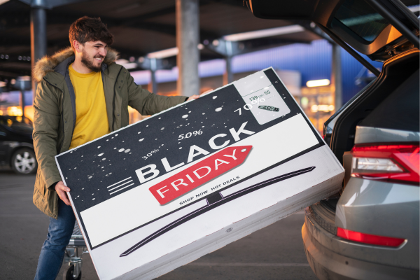 Man loading a TV set in car from a Black Friday sale in Canada