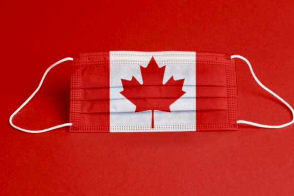 Picture of a face mask with a map of Canada on it.  The mask is on a red background.