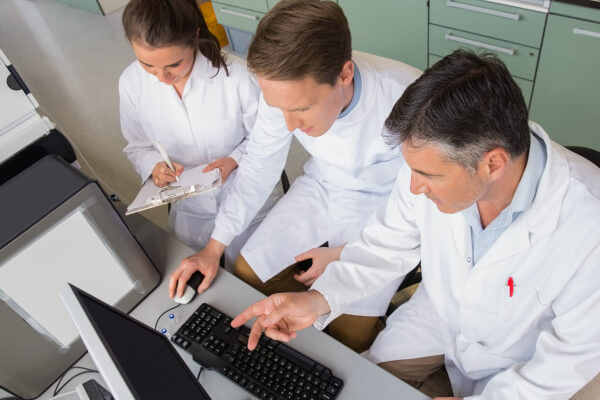 Three pharmacists going over information on computer