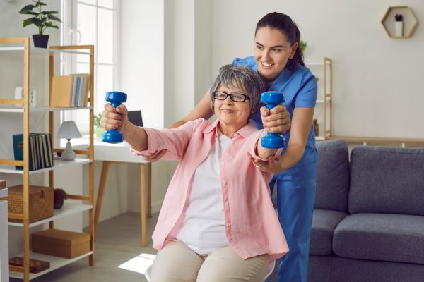 Physiotherapist helping senior stretch with light weights