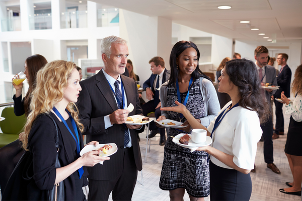 A group of delegates networking during a sales conference. Networking is an effective way to build your sales and marketing career in Canada.