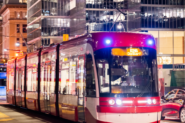 A streetcar travelling along King St. in downtown Toronto at night. 
