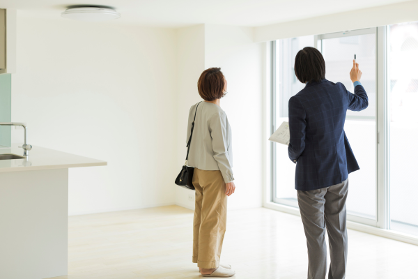 A real estate agent is showing a woman an apartment for rent. 