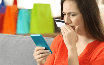 Young woman viewing her credit card information on her mobile phone and looking worried
